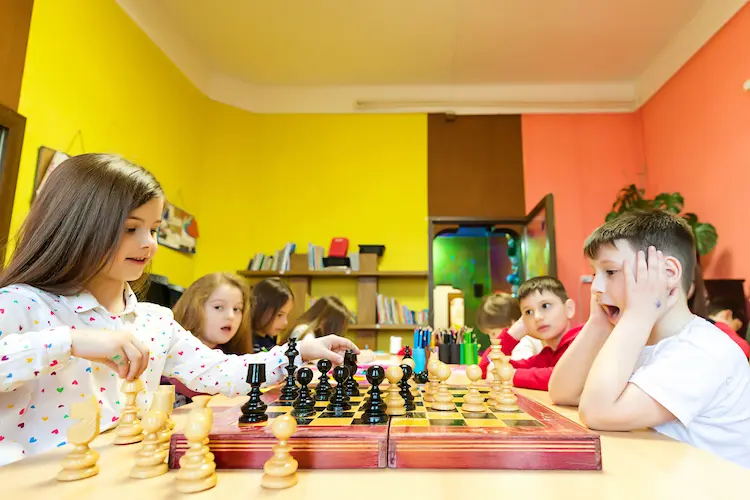 Copii jucând șah la Afterschool Hera Kids din Târgoviște.