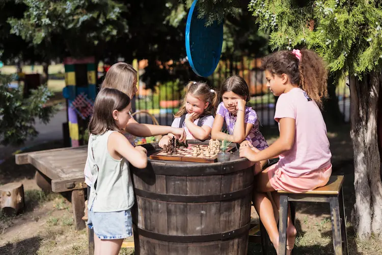 Copii jucând șah în curtea Hera Kids.