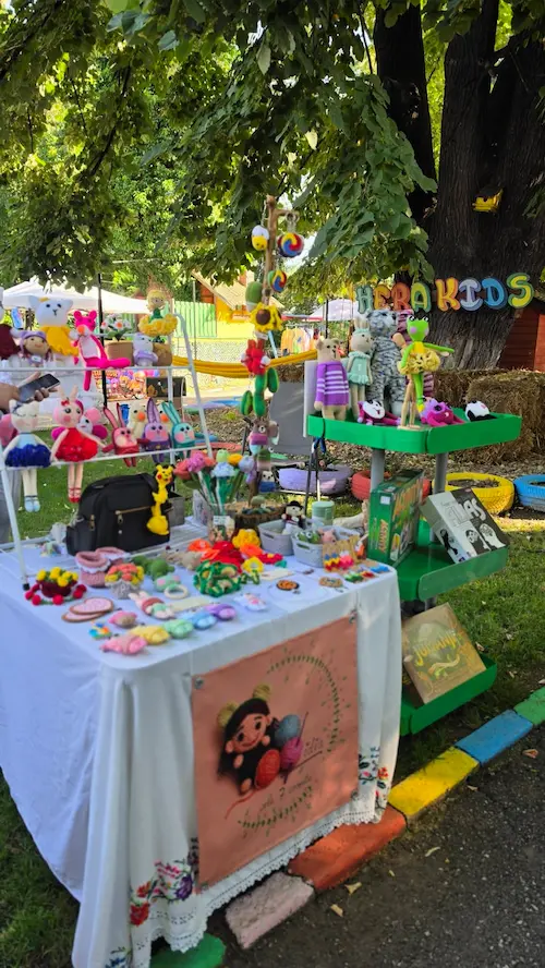 Stand cu obiecte handmade la un eveniment Hera Kids în curte.
