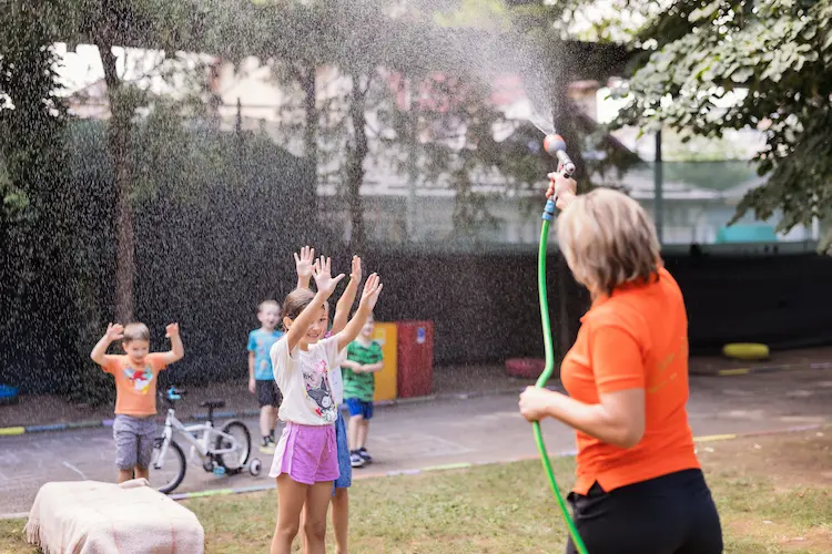Copii jucându-se cu apă în curtea Hera Kids.