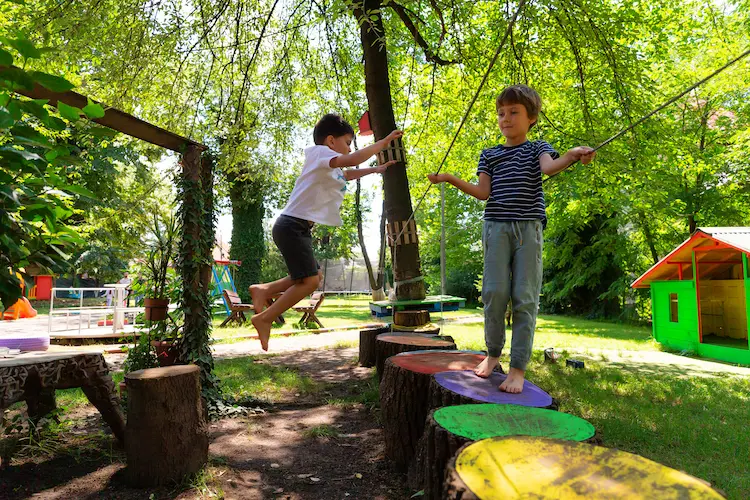 Copii pe un traseu de echilibru în curtea Hera Kids, la Școala de Vară.